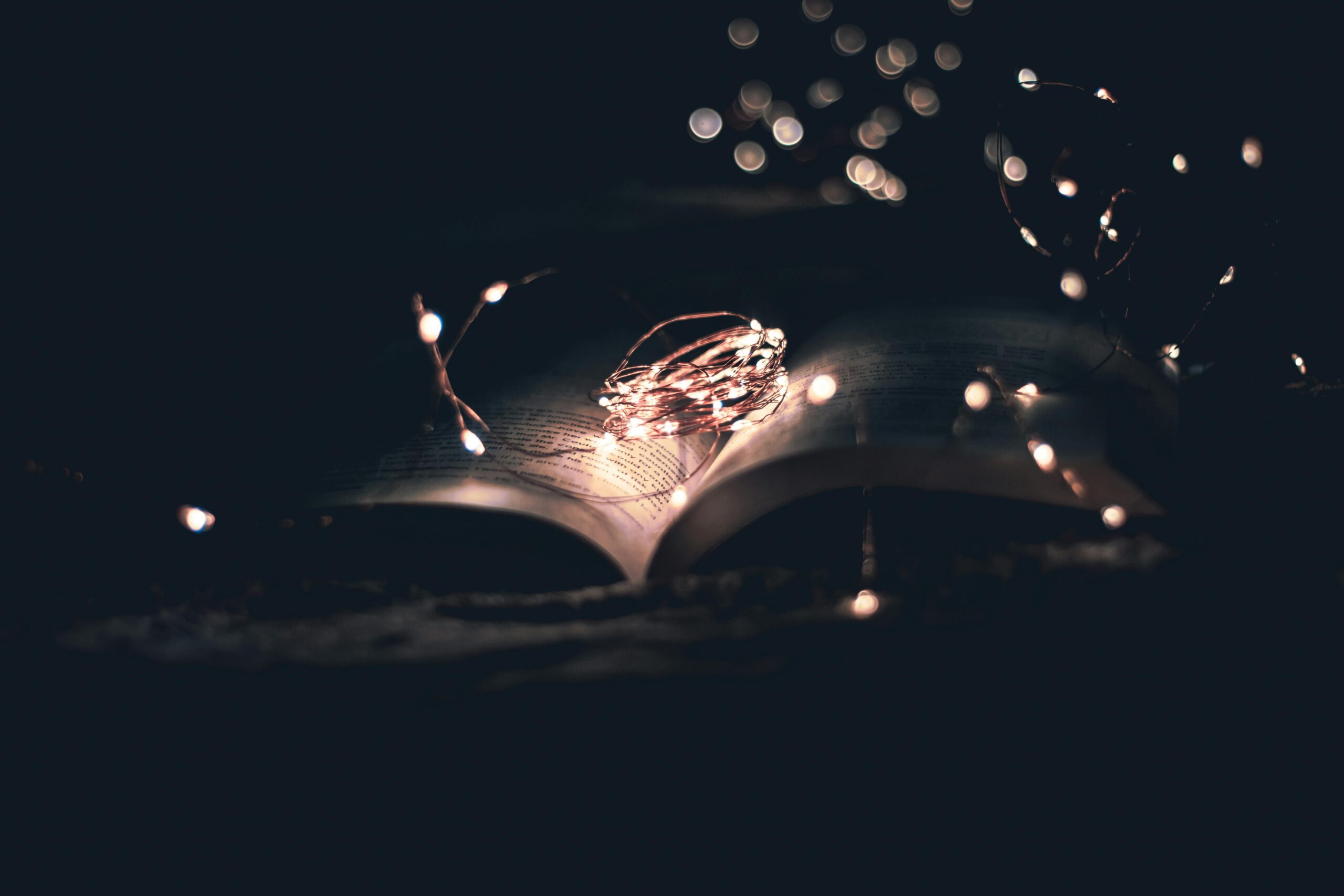 a book in night darkness, with string lights sitting on it