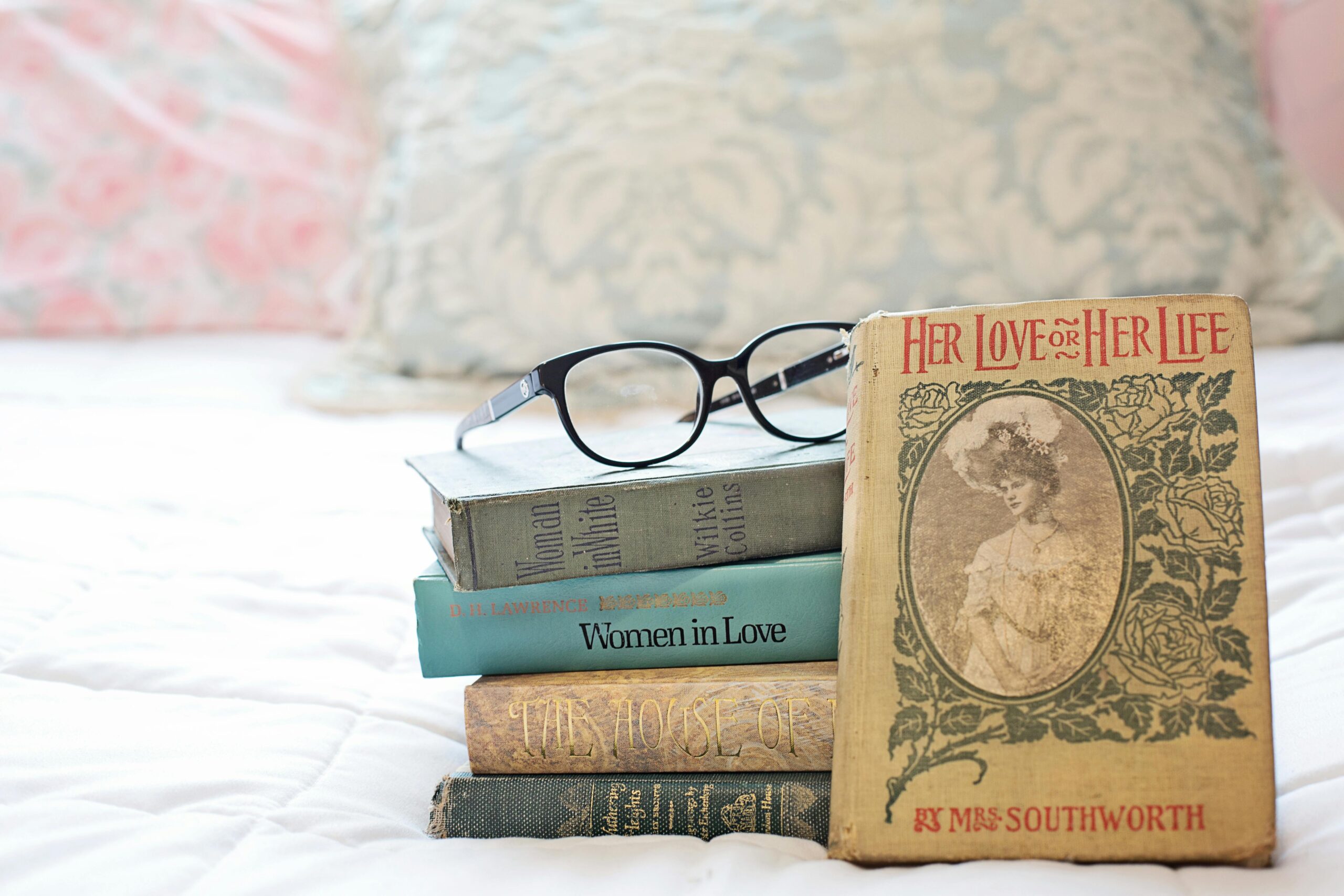 stack of books with eyeglasses on top